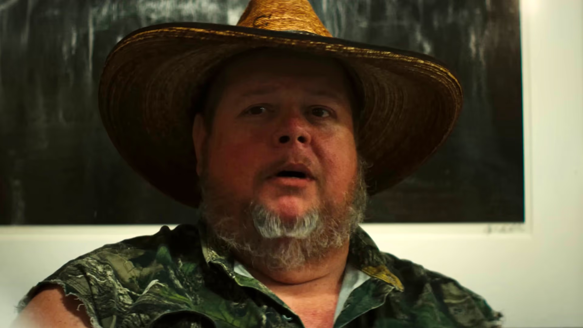 Large man in small hat.
