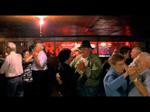 A busy dance hall with Schultze dancing with an American woman.