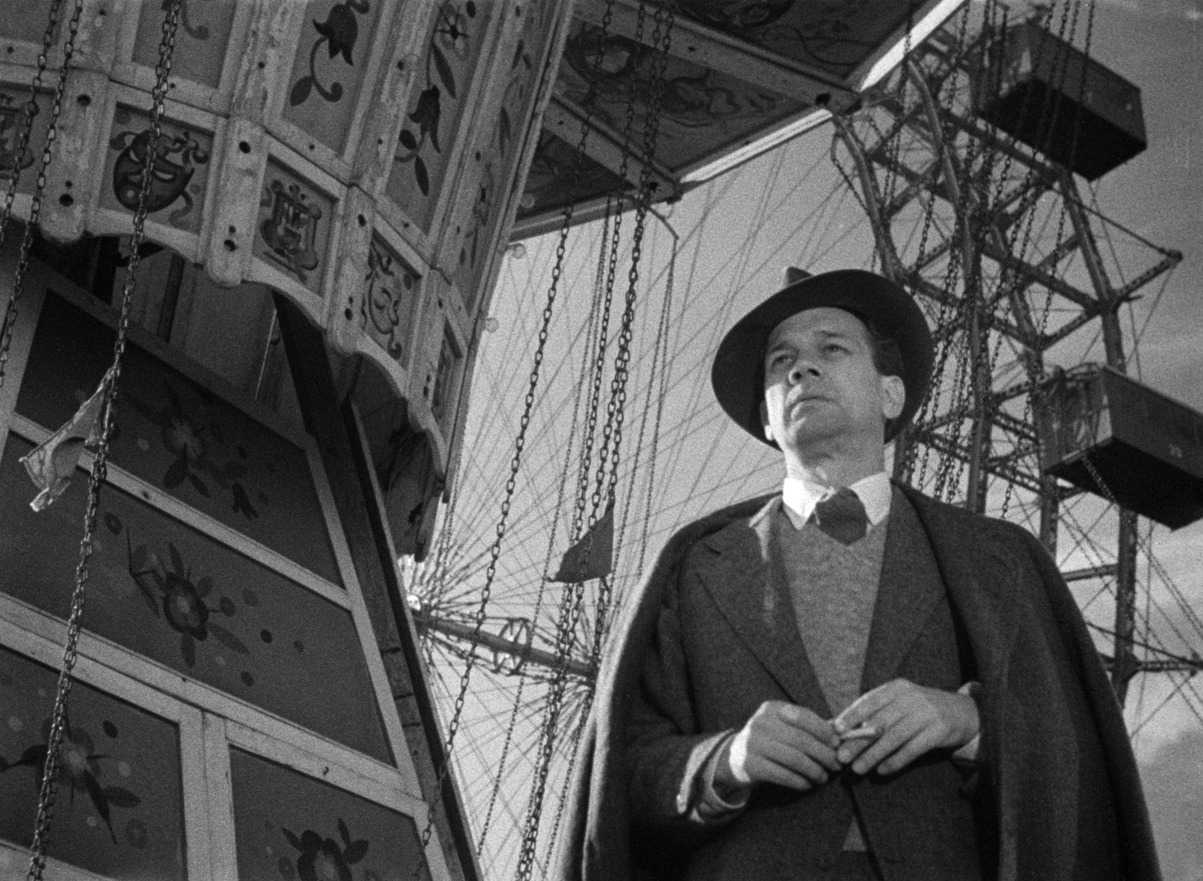 Man standing in front of a Ferris wheel.